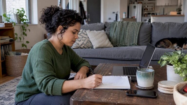 Woman calculating net worth at home